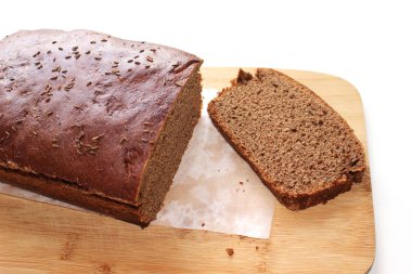 Beyaz kağıt ve beyaz arka plan üzerinde izole ahşap tahta üzerinde dilimlenmiş koyu çavdar kenevir tohumu ekmek