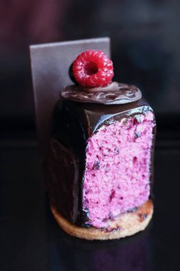 Üstüne ahududu ile dilimlenmiş sırlı siyah frenk üzümü mus çikolata tatlı