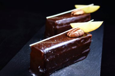 Cevizli fındık ve elma dilimleri ile çikolatalı kek parçaları gümüş tozu ile toz