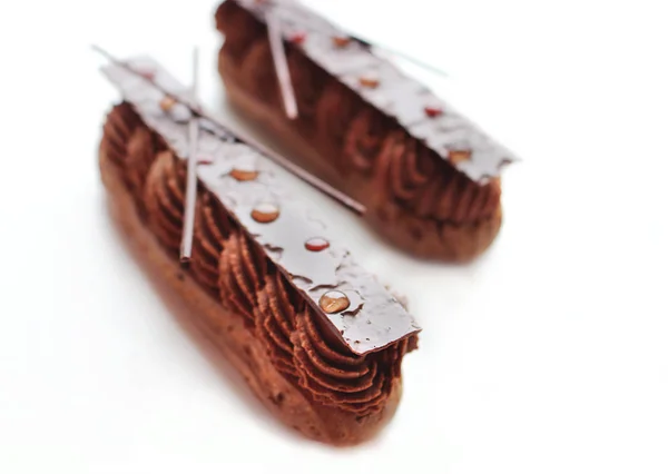 Két csokoládé ganache eclairs fényes csokoládé dekorációkkal — Stock Fotó