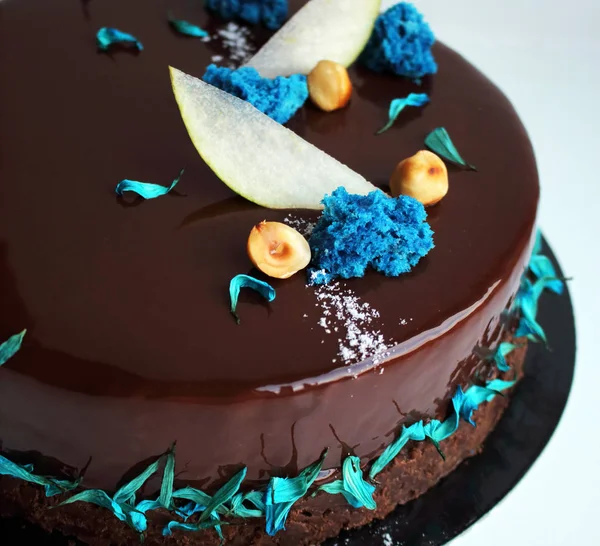 Błyszczące ciasto czekoladowe z orzechami laskowymi, plastry jabłkowe i niebieska gąbka — Zdjęcie stockowe
