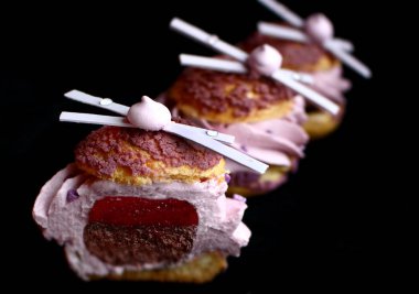 Çikolata ve beze süslemeleri ile dilimlenmiş lavanta profiterole