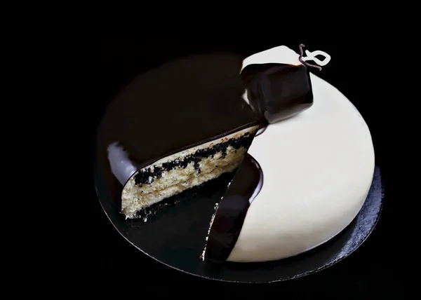 Gâteau de noix de coco et de graines de pavot noir et blanc tranché sur fond noir — Photo