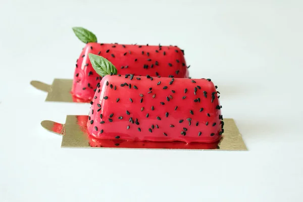 Rote Wassermelonen glasierte Desserts mit schwarzem Sesam und Basilikumblättern auf goldenen Untersetzern — Stockfoto