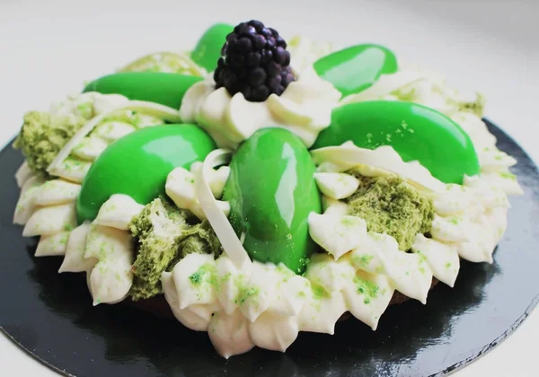 Πράσινο κέικ λουλουδιών με κρέμα, σφουγγάρια φιστίκι μικροκυμάτων και βατόμουρο — Φωτογραφία Αρχείου