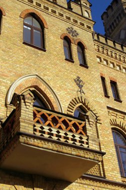 Kemerli pencereleri ile sarı tuğla duvarüzerinde eski gotik kale balkon