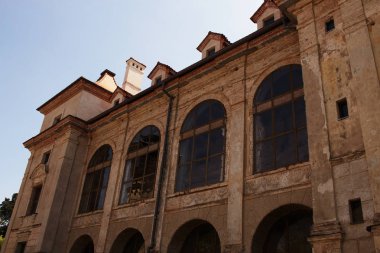 Duvar duvar resimleri ve mavi gökyüzü arka plan üzerinde büyük kemerli pencereler ile eski Avrupa saray binası