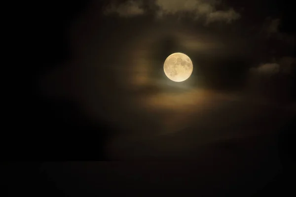 Luna llena amarilla en el cielo nublado oscuro —  Fotos de Stock