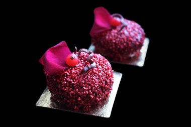 Kırmızı frenk üzümü meyveleri ve yenilebilir kırmızı gül yaprakları ile kırmızı dokulu tatlılar