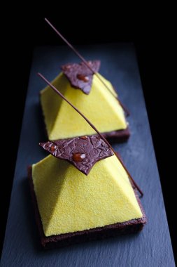 Koyu çikolata dekorasyonlu brownie sarı dokulu piramit tatlı