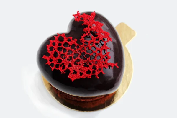 Dessert en forme de coeur noir avec décoration en dentelle rouge — Photo