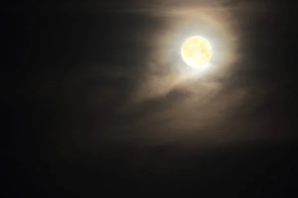 Full moon in clouds on black sky background — Stock Photo, Image