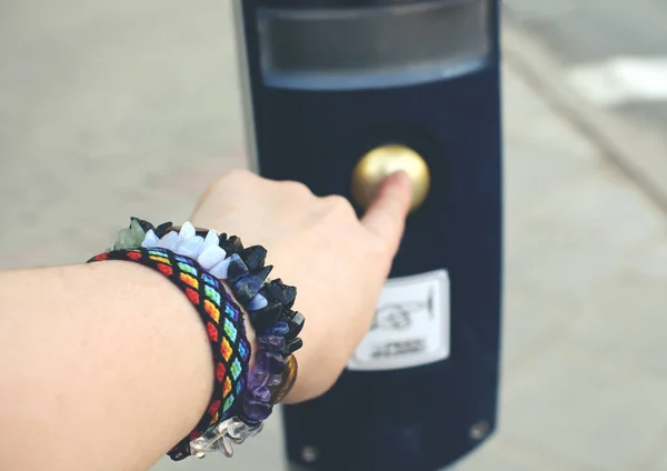 Free spirit girl hand waiting for green light pressing traffic light button