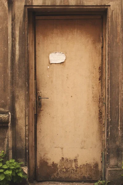 Kağıt parçası ile eski yaşlı yıpranmış kahverengi kapı — Stok fotoğraf
