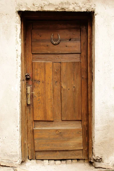 Коричневі старовинні дерев'яні двері з підкови на удачу — стокове фото
