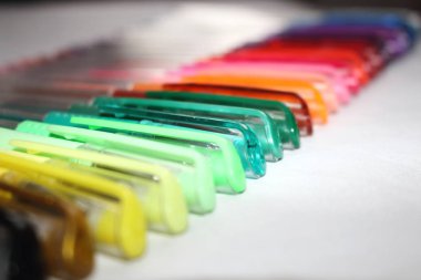 Yatay bir satırda yere serilmiş renkli jel kalemler