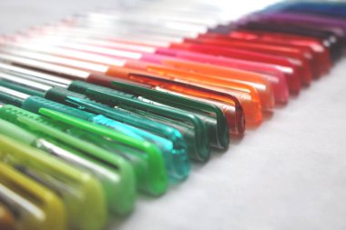 Yatay bir satırda yere serilmiş renkli jel kalemler