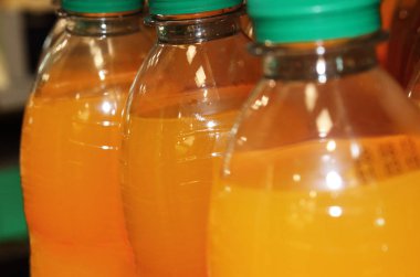 Yeşil kapaklı ve turuncu sıvılı plastik şişeler