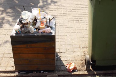 Vilnius Litvanya - 04 22 2019: Çöp kutusu güneşli bir günde plastik ve kağıt bardak ile doldurulmuş