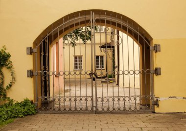 Sarı ev duvarında zincir ve asma kilit ile kapalı metal kapı