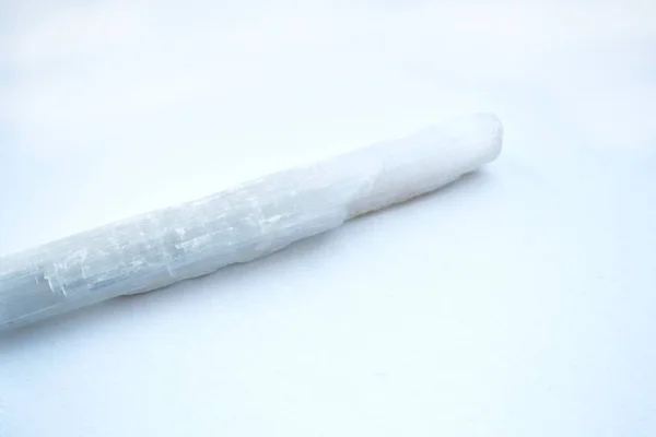 Bâton de cristal blanc sélénite sur fond blanc — Photo