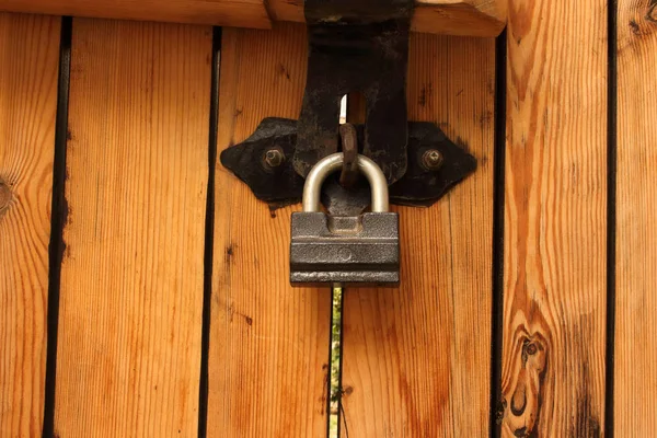 Cadeado pendurado em portas de prancha de madeira fechadas — Fotografia de Stock