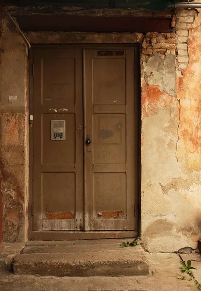 Yıpranmış kirli tuğla duvarda yaşlı koyu ahşap kapı — Stok fotoğraf