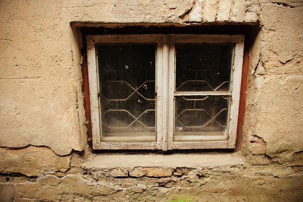 Pequeña ventana sucia en la pared de yeso gris viejo — Foto de Stock