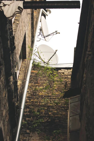 Two satellite dishes on old building roof