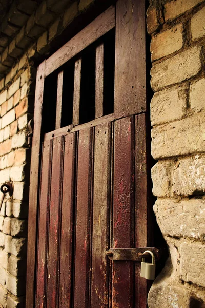 Porta de madeira marrom velho na parede de tijolo branco — Fotografia de Stock