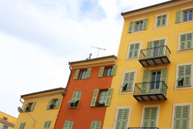 Bulutlu gökyüzü arka plan üzerinde üç renkli binalar