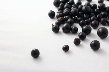 Beyaz arkaplanda siyah frenk üzümü var.