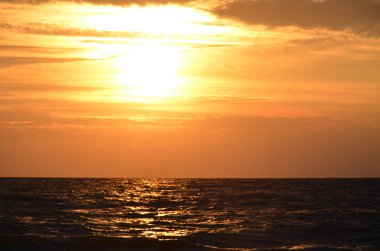 Seashore gökyüzü turuncu tonları bulutlar ve deniz dalgaları güzel doğa parlak gün batımı karanlık su