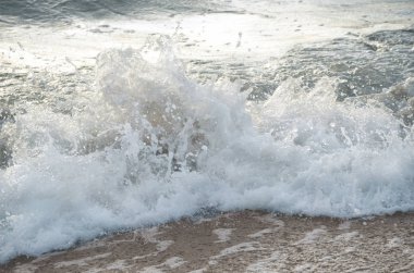 Deniz köpüklü dalgalar kumlu sahil arka plan üzerinde sıçramaları