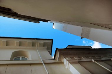 İki beyaz tarihi bina arasında mavi gökyüzü