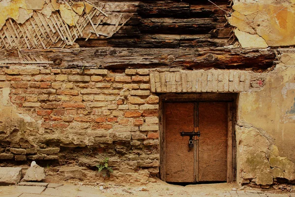 Tuğla duvarda küçük kahverengi ahşap kapı — Stok fotoğraf