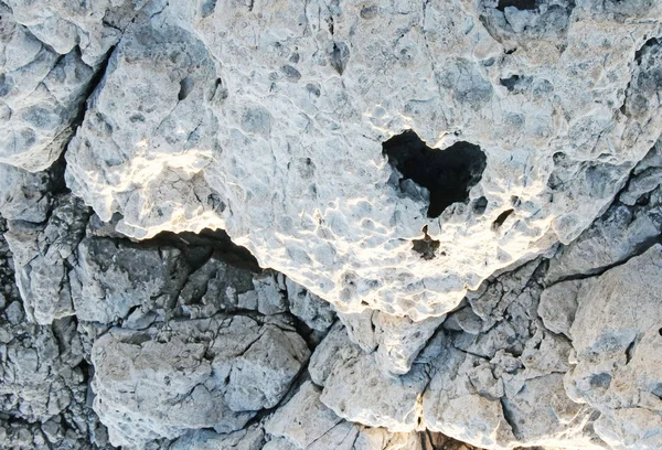 Heart shaped hole in a white stone textured wall — Stock Photo, Image