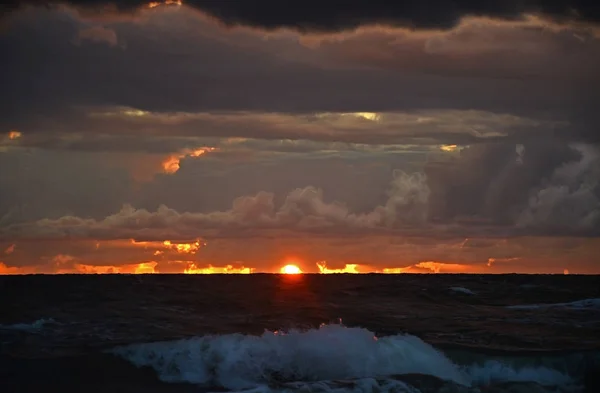 Dark seashore sky orange tones clouds and sea waves beautiful nature bright sunset dark water — Stock Photo, Image