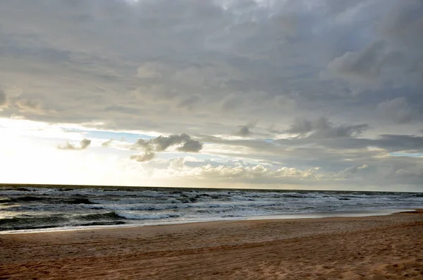 Seashore gökyüzü mavi tonları koyu ağır bulutlar ve deniz dalgaları kum plaj güzel doğa gün batımı