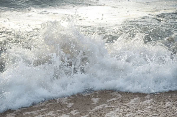 Deniz köpüklü dalgalar kumlu sahil arka plan üzerinde sıçramaları