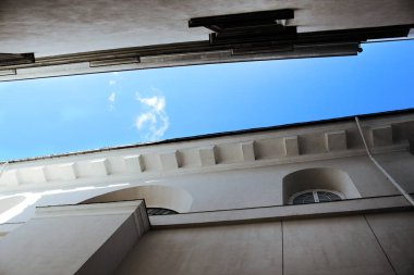 İki beyaz tarihi bina arasında mavi gökyüzü