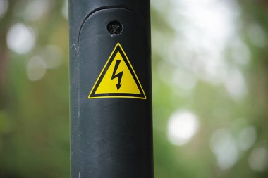 Bir tel direğinde sarı üçgen elektrik uyarı işareti