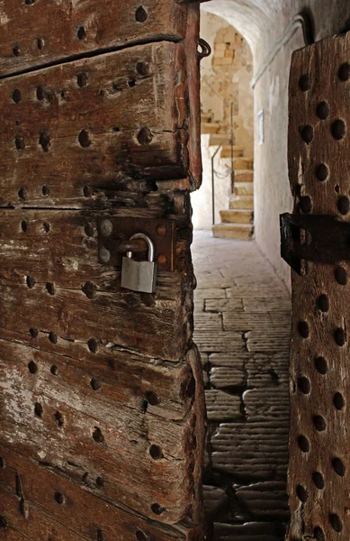 Puerta envejecida con candado moderno entrada antigua y espeluznante a un antiguo castillo — Foto de Stock