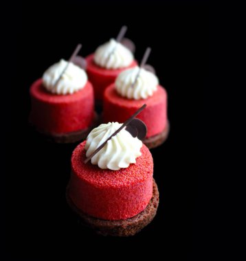 Krem üst ve çikolata dekor ile kırmızı dokulu tatlılar