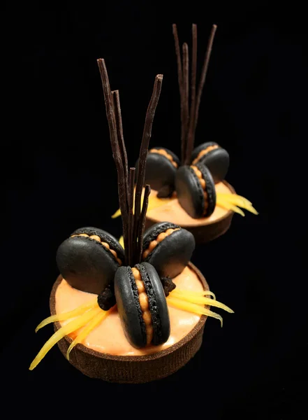 Orange chocolate tarts with black french macarons and persimmon