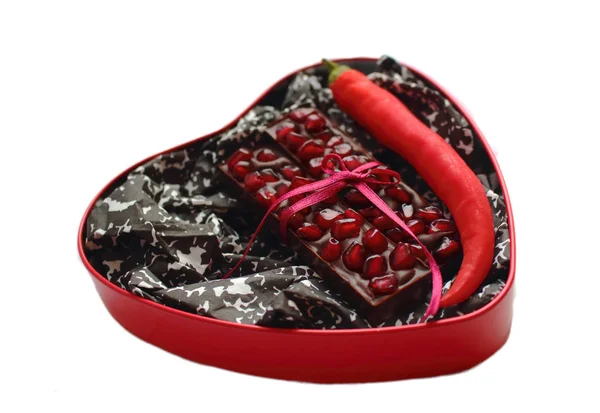 Barres de chocolat au lait grenade attachées avec ruban rouge arc dans une boîte en forme de coeur — Photo