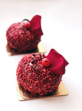 Kırmızı desenli, üzümlü ve beyaz arkaplanda kırmızı gül yaprağı olan şeker tatlısı.