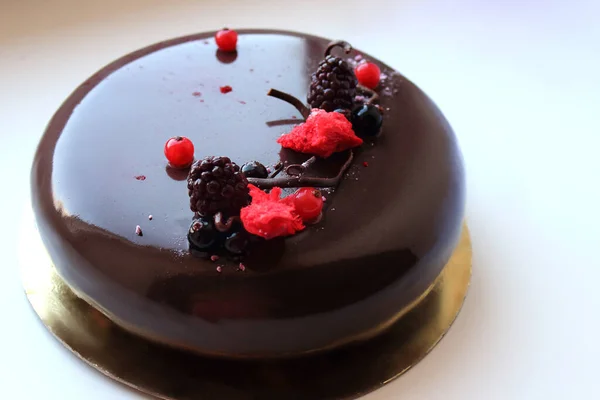 薄い背景に果実とダークグレーズチョコレートケーキ — ストック写真