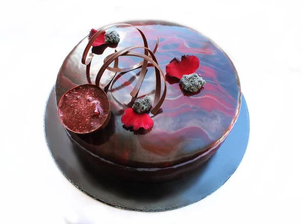 Gâteau marbré foncé rond avec pétales de fleurs et décorations au chocolat — Photo