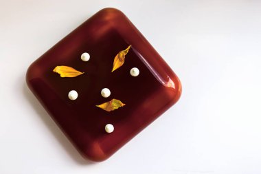 Kare çikolatalı pasta, sarı ayçiçeği yaprakları ve yukarıdan aşağıya doğru küçük bir öpücük.